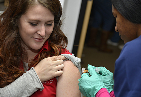 Woman receives a flu shot from nurse