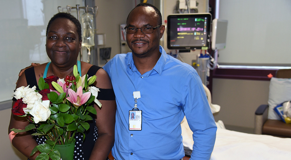 A woman accepts flowers from her VA nurse