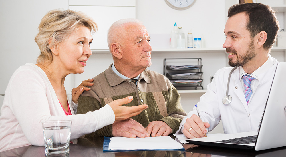 Mature couple having consultation with male doctor in hospital
