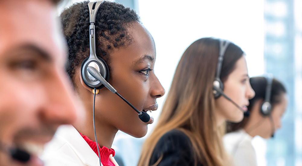 A profile photo of four call center employees talking into headsets