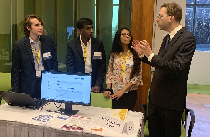 IMAGE: Dr. Gil Alterovitz, Director, National Artificial Intelligence Institute, Department of Veterans Affairs, (right) with members of the Girls Computing League discuss the Clinical Trial Selector project at last week’s “demo day” at the U.S. Census Bureau, Department of Commerce.