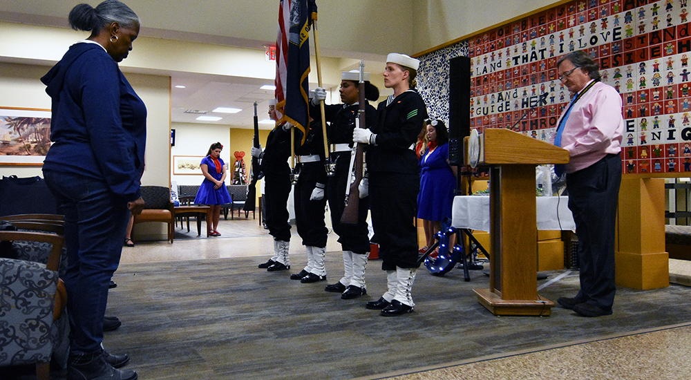 Chaplain speaks as color guard presents the flags