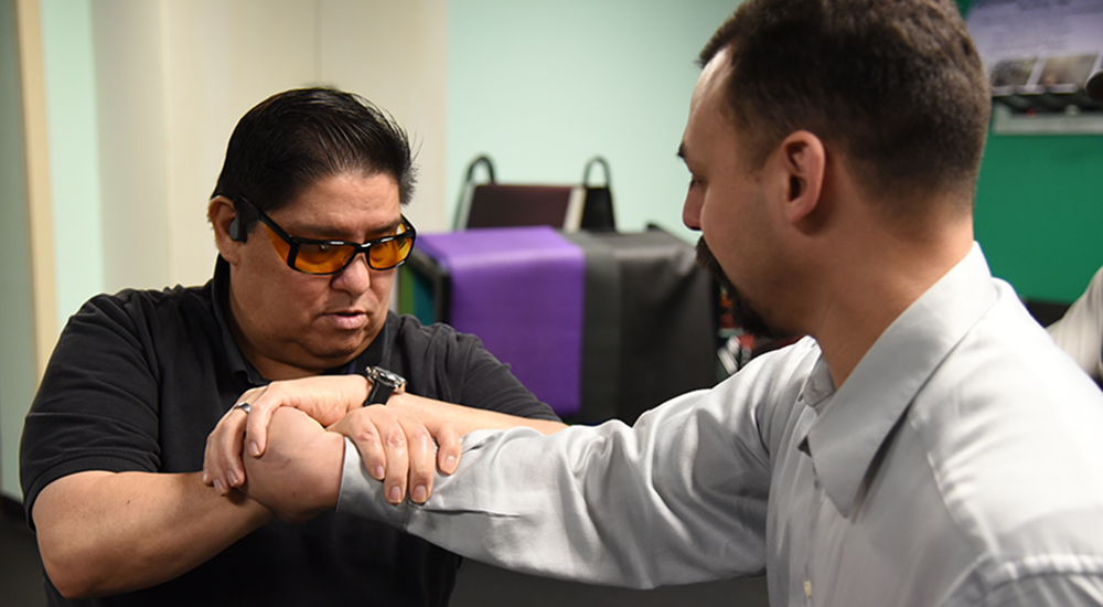 An instructor teaches a blind Veteran a self-defense move