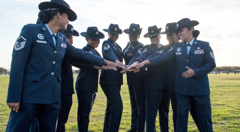 Group of Air Force women placing hands in a circle