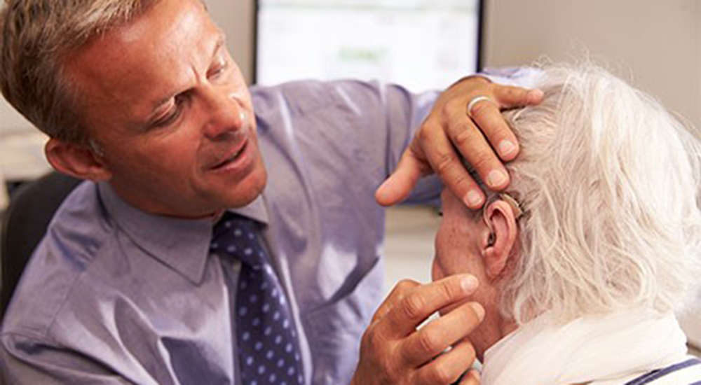 Doctor examining an elderly patient’s ear