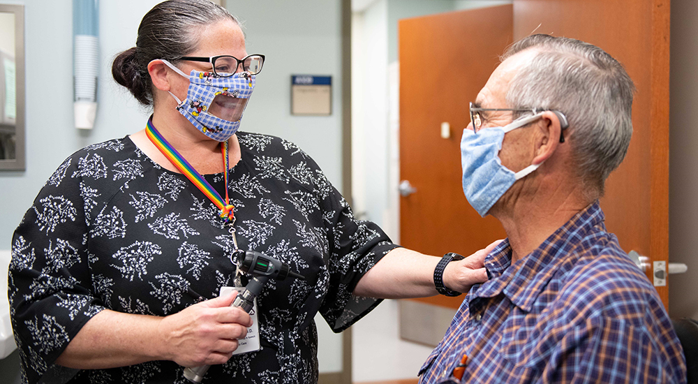 Woman wearing special mask talks to patient wearing mask