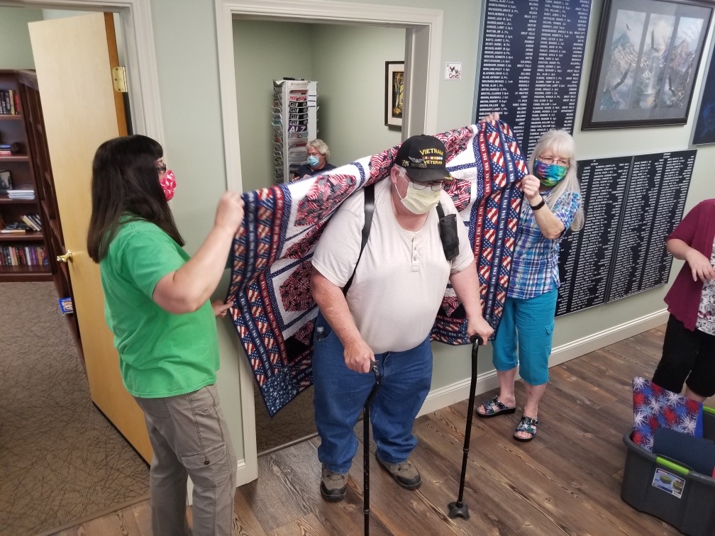 Vet Center welcomes home Vietnam Vets with quilts.