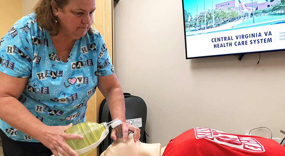 Woman demonstrates CPR simulation with mannequin
