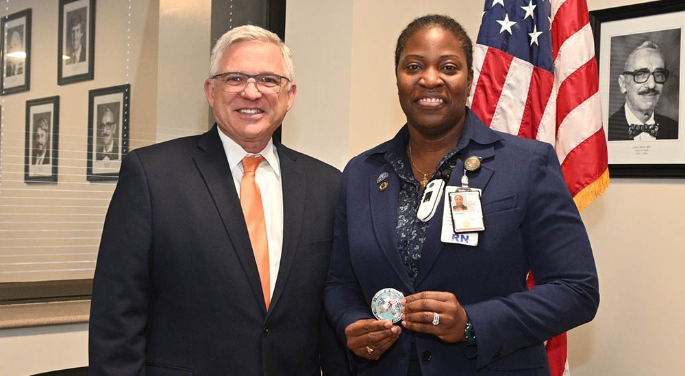 woman nurse receives award from man in suit
