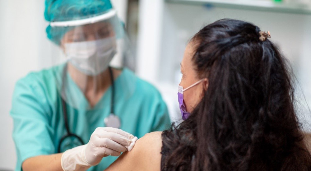 Health provider giving a woman a flu vaccine
