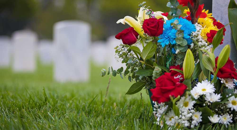 white grave markers and flowers at a national cemetery