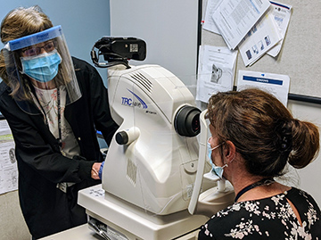 Clinician scanning a patient’s eyes