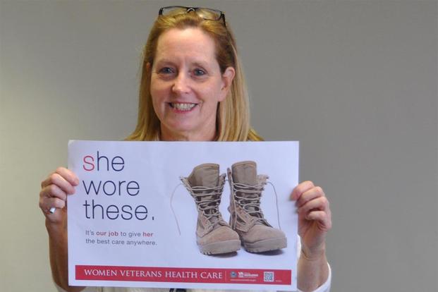 woman veteran holding va health care sign