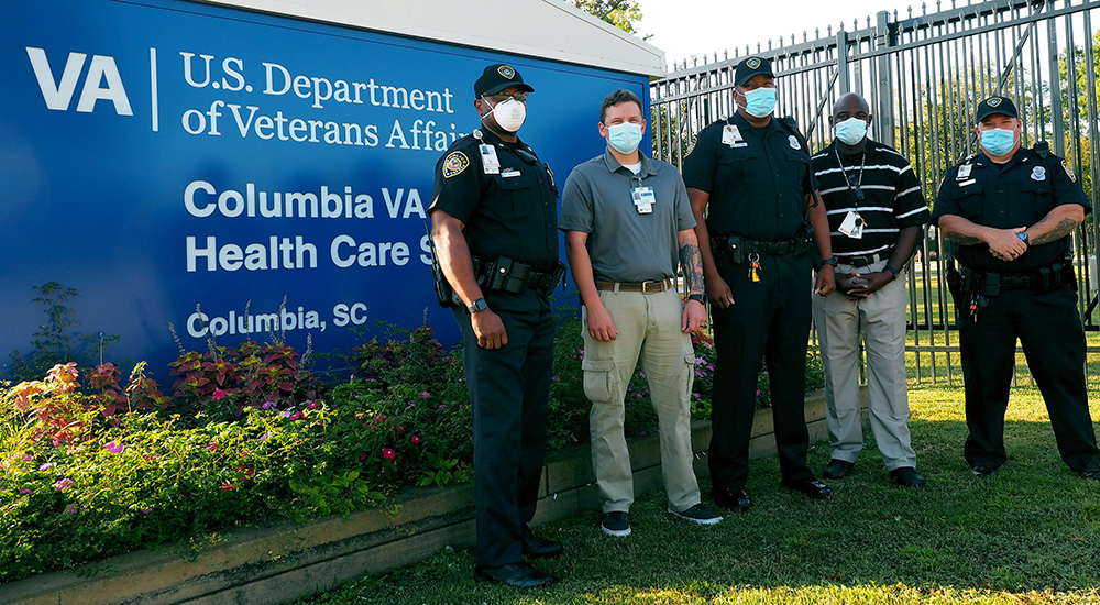 Five police officers in front of hospital sign