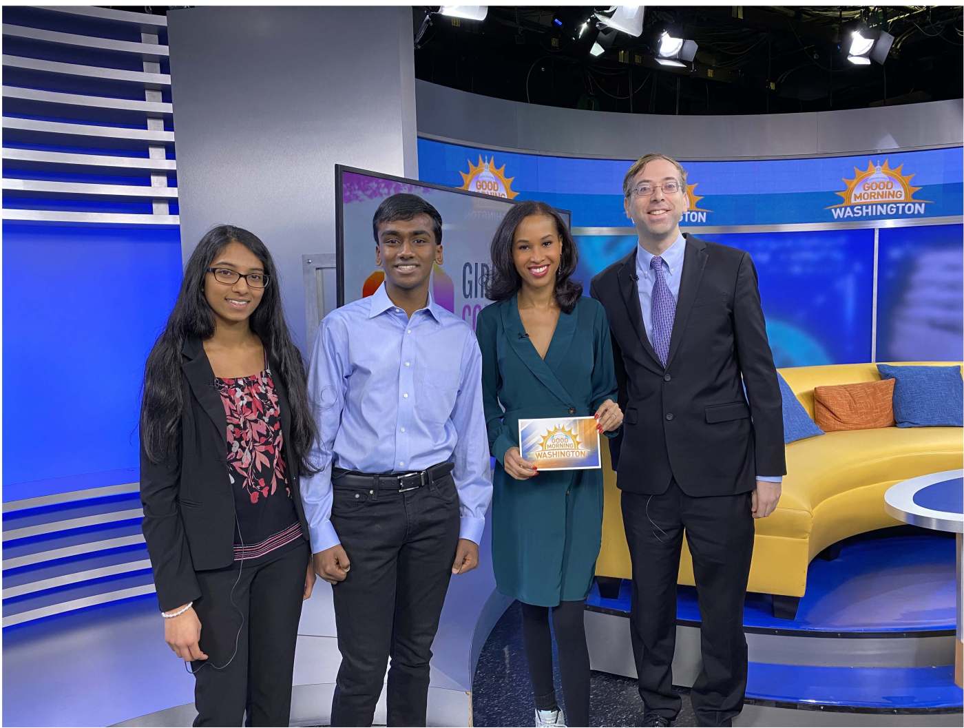 Members of the Girls Computing League and Dr. Gil Alterovitz discuss their participation in the 2019 AI Tech Sprint on Good Morning Washington. From left to right: Shreeja Kikkisetti, Neeyanth Kopparapu, Adrianna Hopkins, a reporter with ABC News 7, and Dr. Gil Alterovitz. (Photo was taken prior to COVID-19 pandemic.)