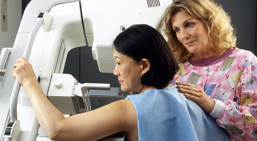 Nurse assisting women with mammogram
