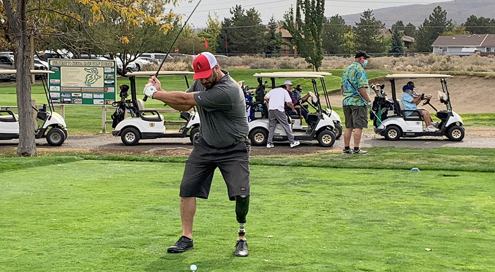 Man with prosthetic leg swings golf club