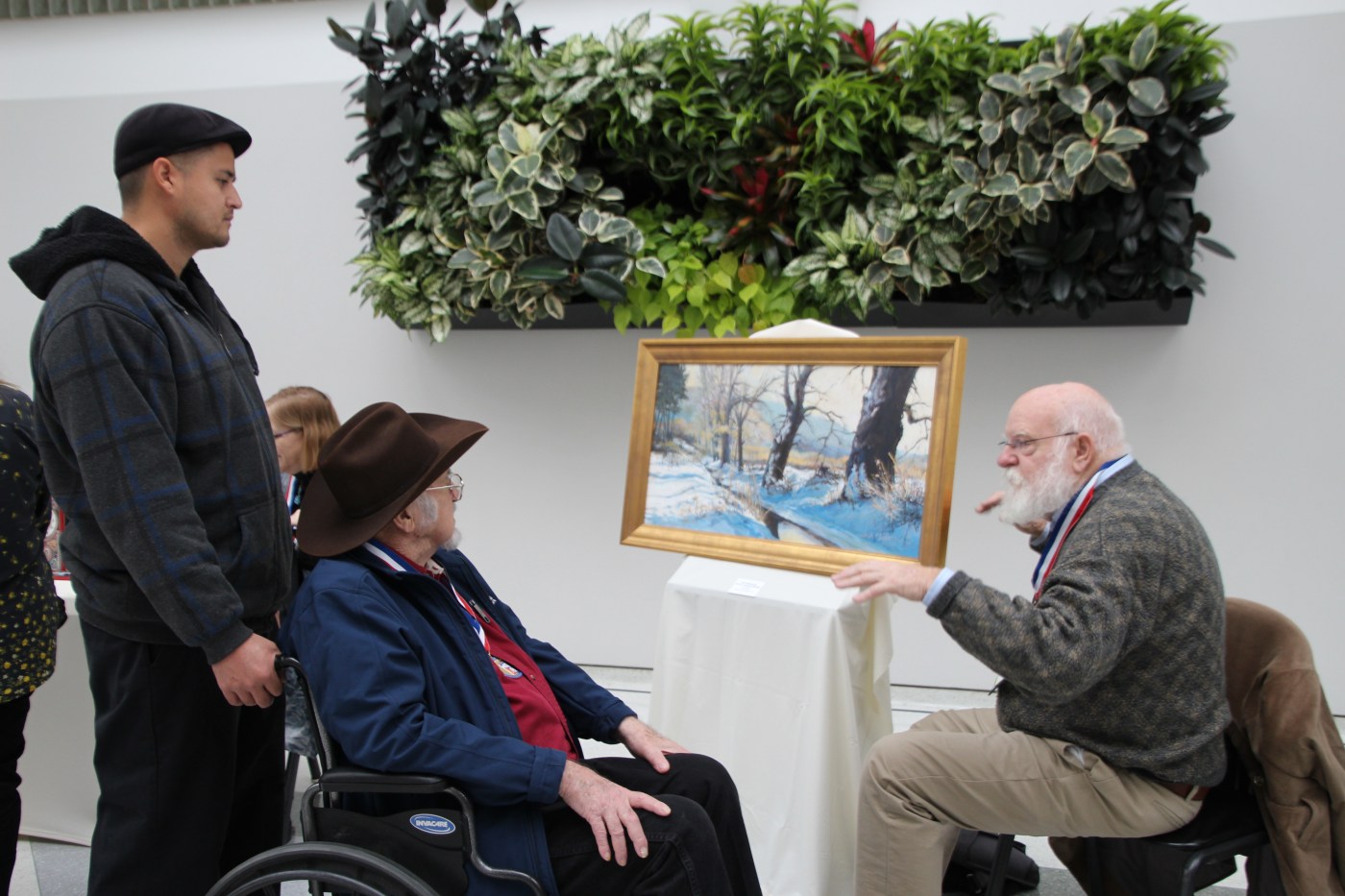 man shows his painting to visitors