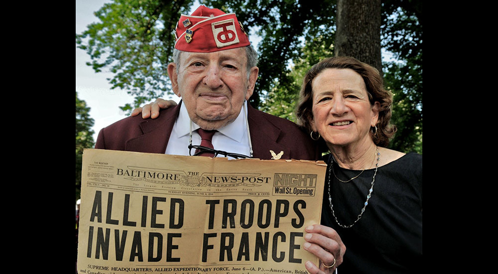 Veteran and daughter with WWII newspaper