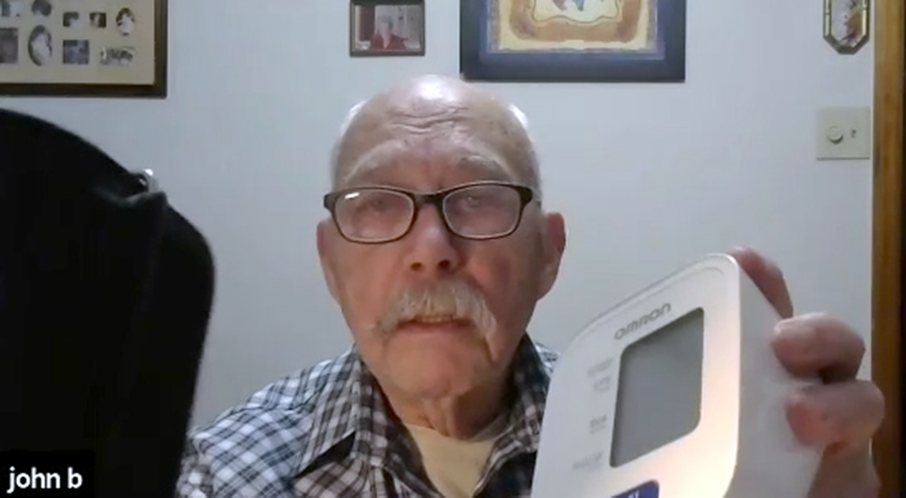 Elderly man holding blood pressure monitor