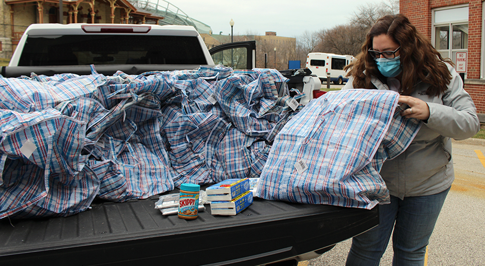 Woman collects kits for homeless from back of truck
