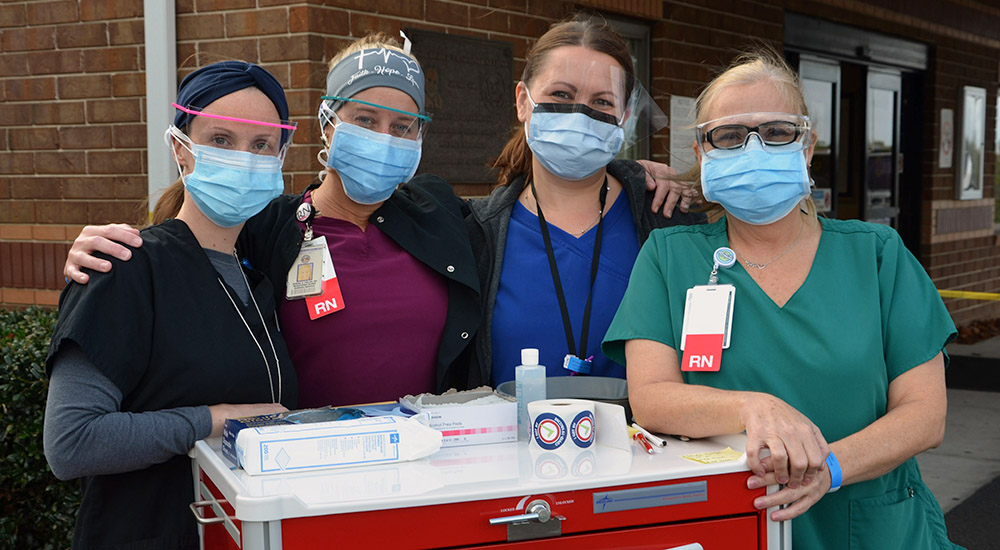 Four nurses with mobile vaccination unit