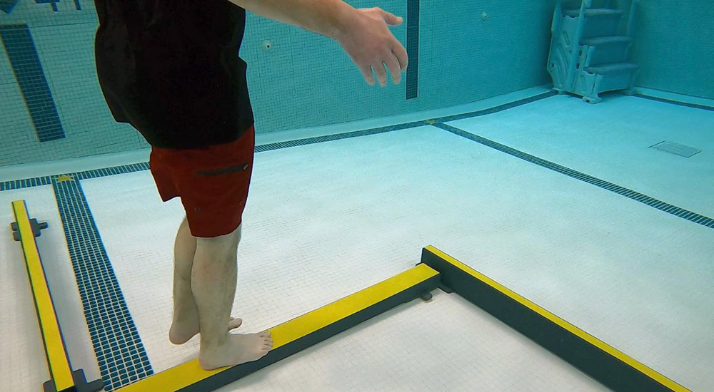 Man walking on balance beam in pool