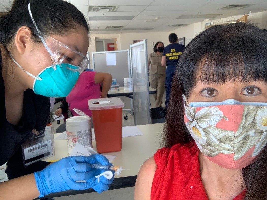 Theresa Clay (right), a member of Navajo Nation, receives her COVID-19 vaccine booster shot from a nurse with the Indian Health Service (IHS), Shayla Jim, during a recent IHS vaccination event in Albuquerque.