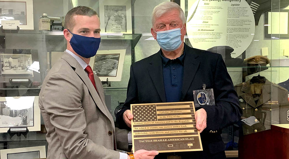 Blind Veteran presenting braille flag to hospital director