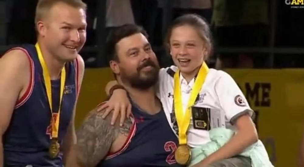 Man and daughter holding medals at THIS event