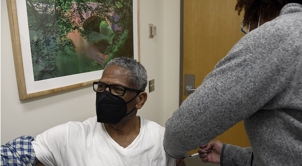 Man wearing mask receiving vaccine