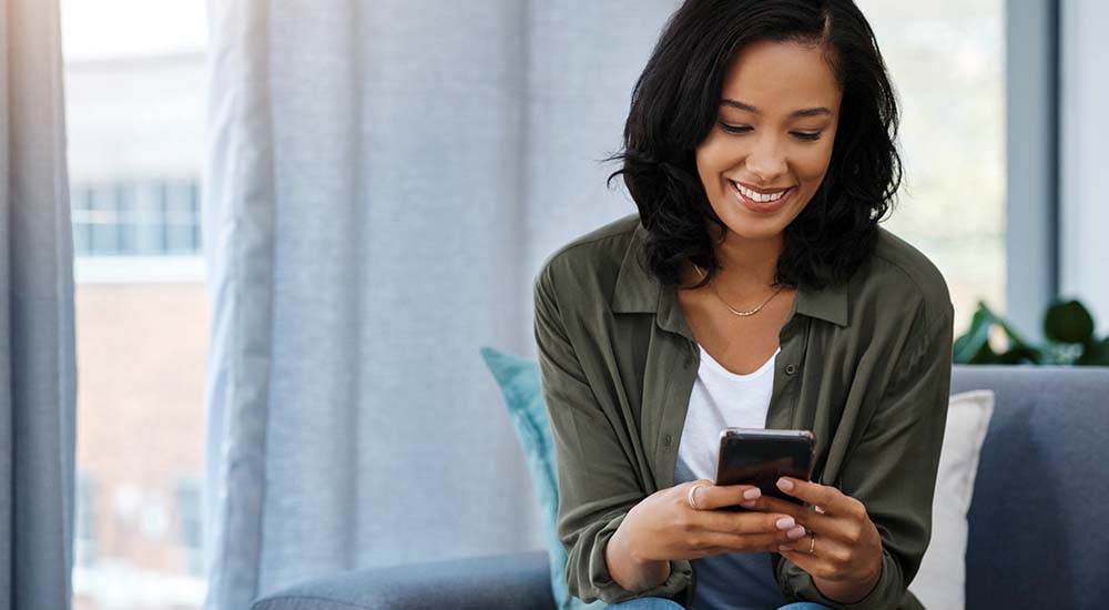 Smiling woman reading cell phone