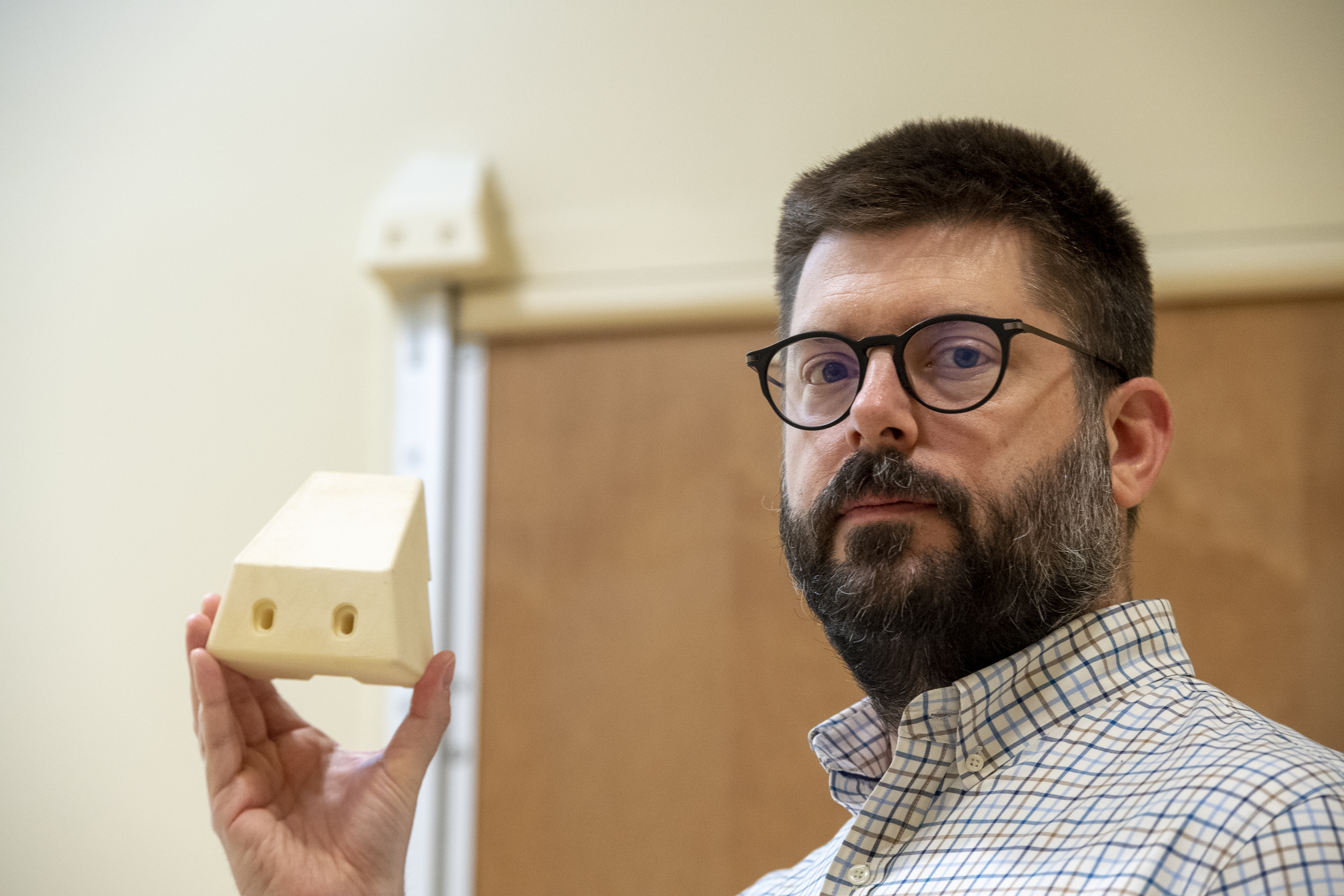 Frank Moore, the suicide prevention coordinator at VA Pittsburgh, displays the 3D block that was installed on all of the bathroom doors in patient rooms in the facility’s mental health wing to prevent a potential hanging. (Photo by Bill George)