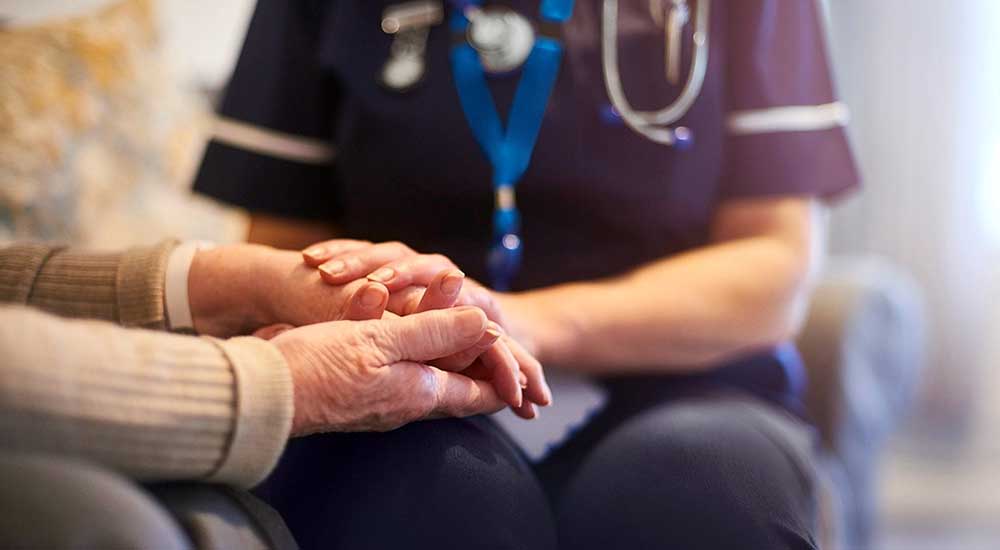 Nurse holding hands with a patient