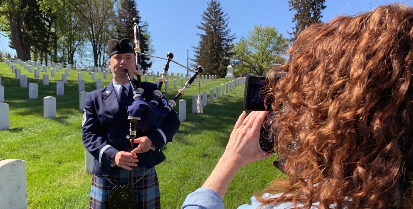 A videographer films Air Force Master Sgt. Adam Tianello, a bagpiper with the Ceremonial Brass, during a video shoot April 26 at Culpeper National Cemetery in Virginia.