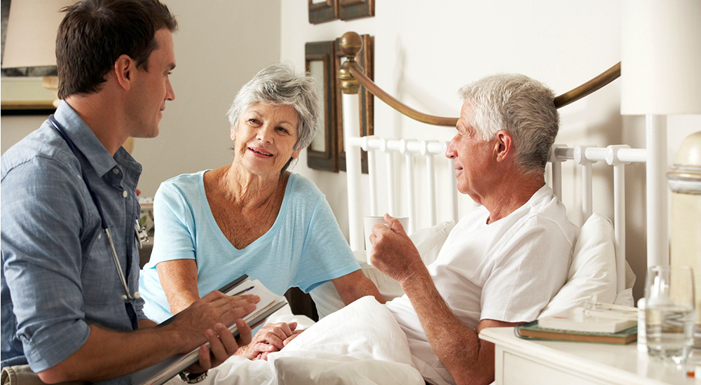 Man talking with man in bed and his wife