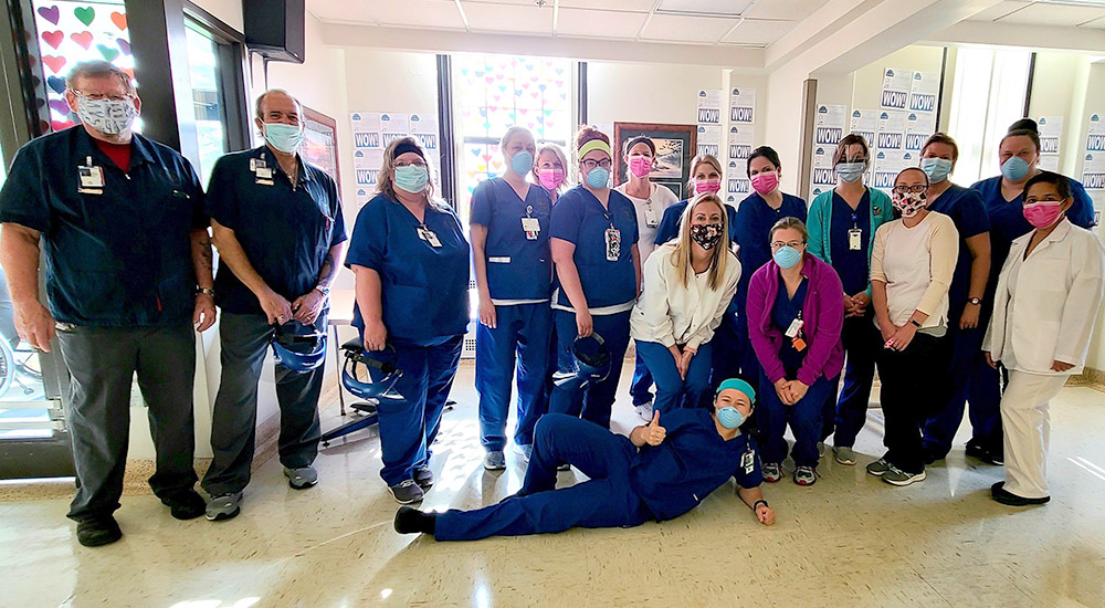 Sixteen medical workers pause for a photo