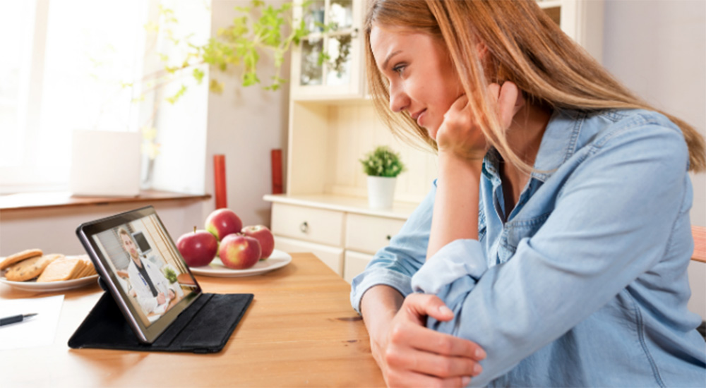 Woman listening to doctor on laptop screen