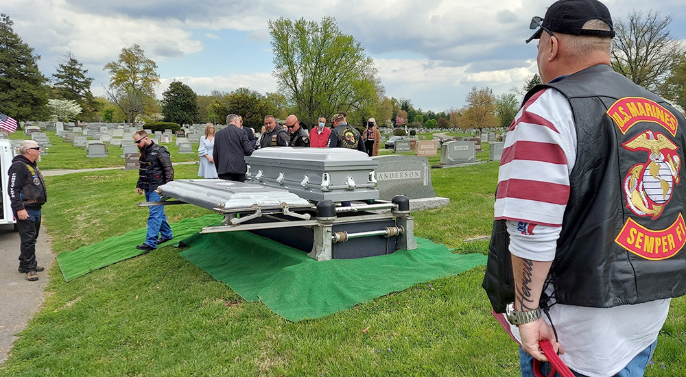 Man at attention for Veteran’s coffin in cemetery