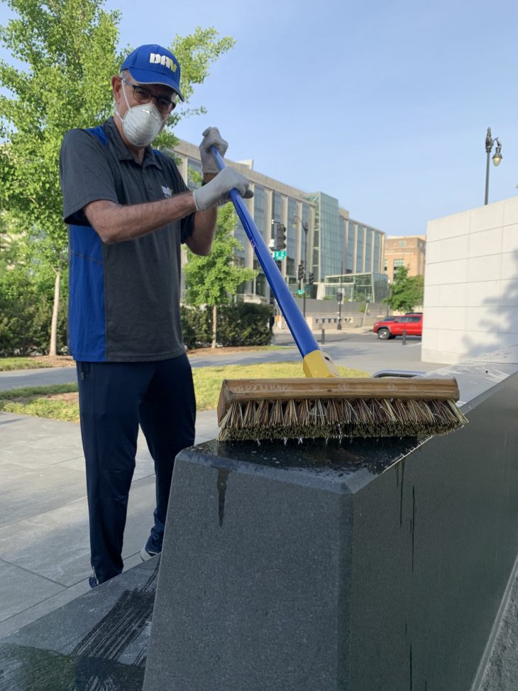 Army Vietnam Veteran Gary Salpini cleans a bench at the American Veterans Disabled for Life Memorial in Washington, D.C.