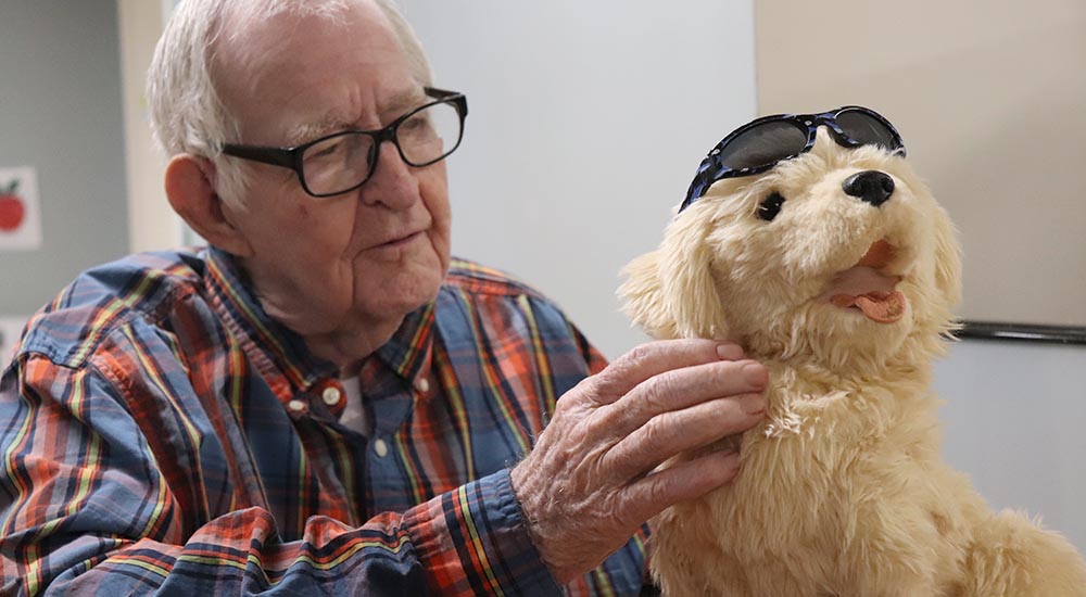 Elderly man holding robot dog
