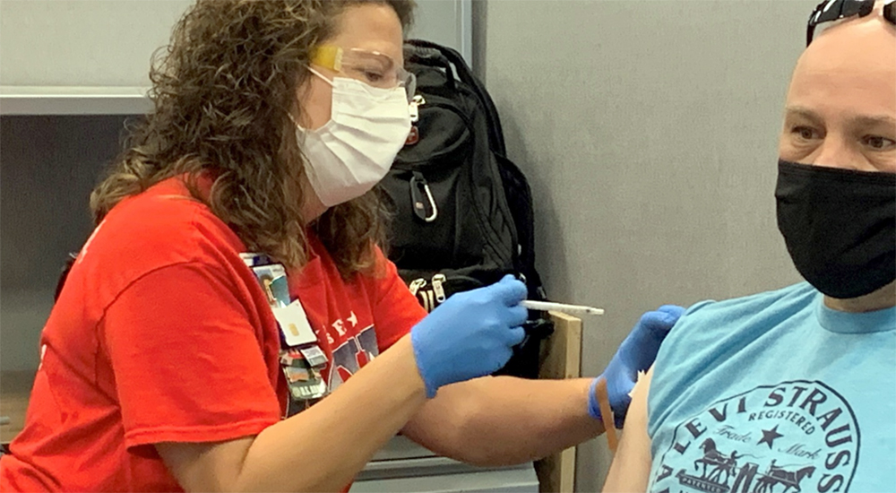Nurse giving male Veteran a vaccine