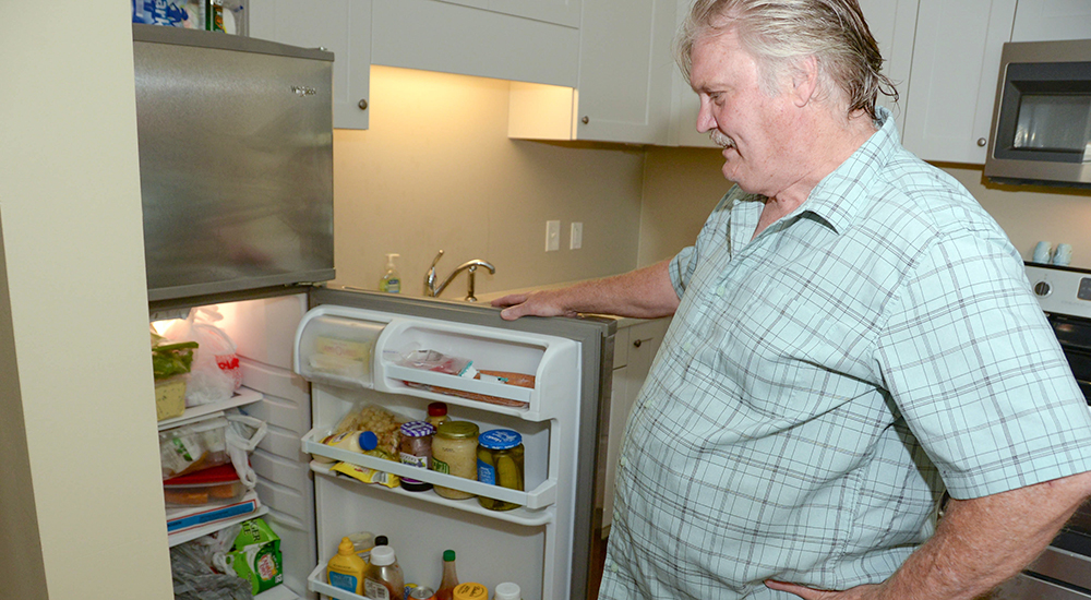 Man looking at food in refrigerator