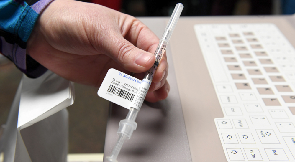 Hand holding vaccine needle