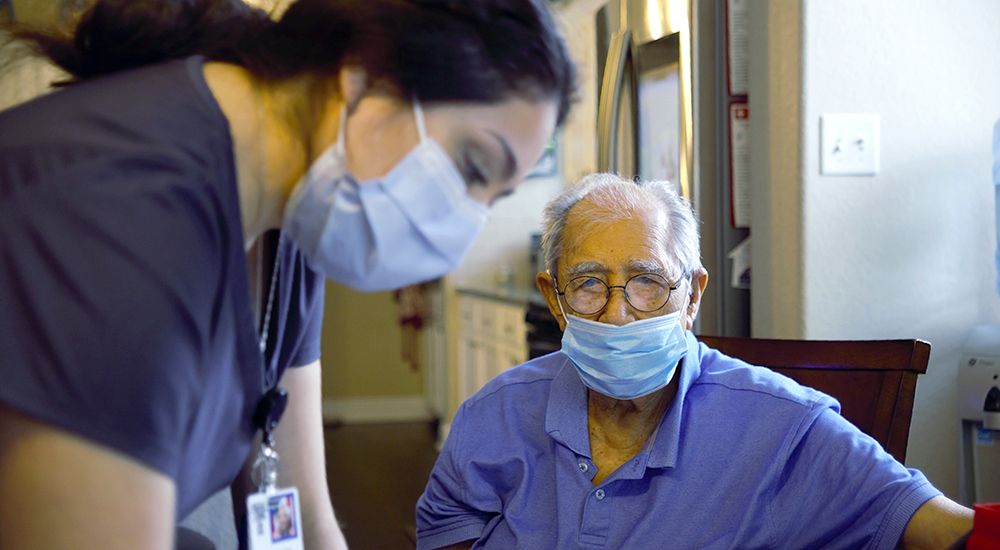 Nurse writing down vitals stats of elderly Veteran