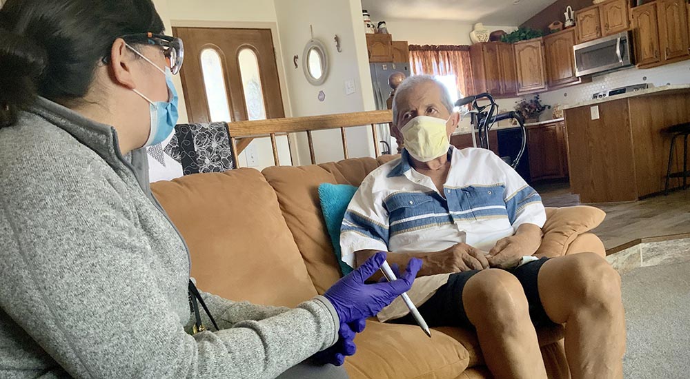 VA doctor talks to a Veteran patient in his home