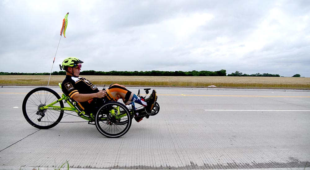 Man riding adaptive bicycle down highway