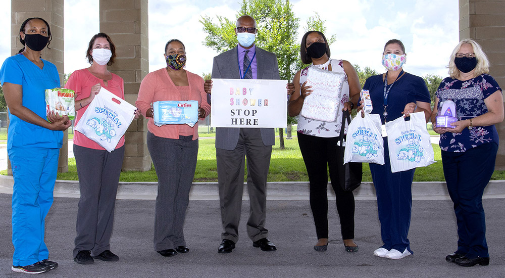 Seven staff members holding signs for maternity services