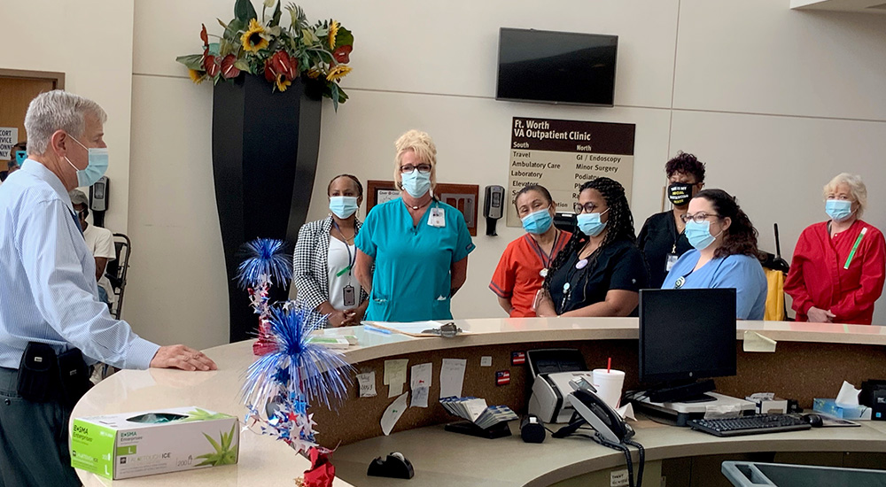 Man speaking to employees in hospital lobby at reopening after ice storm