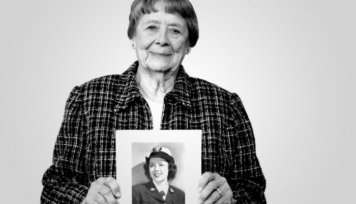 Julia Parson holding a photo of her in uniform.